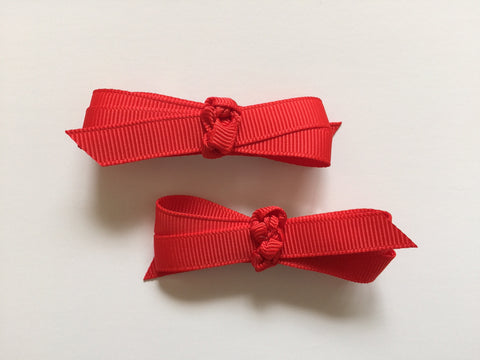 Two hair clips with bright red grosgrain bows