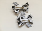 Two hair clips with black & white zebra print grosgrain bows